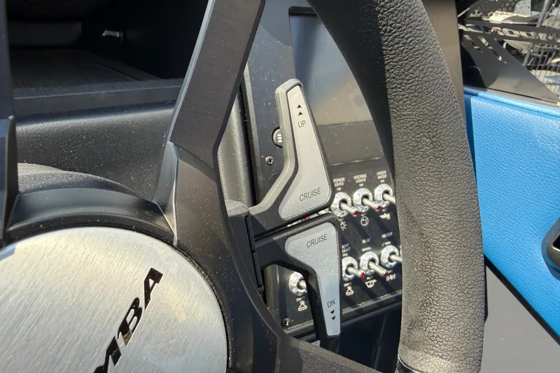 Slide: The Image of Steering wheel controls of 2026 Moomba Tykon boat, featuring cruise settings and switches. - 33