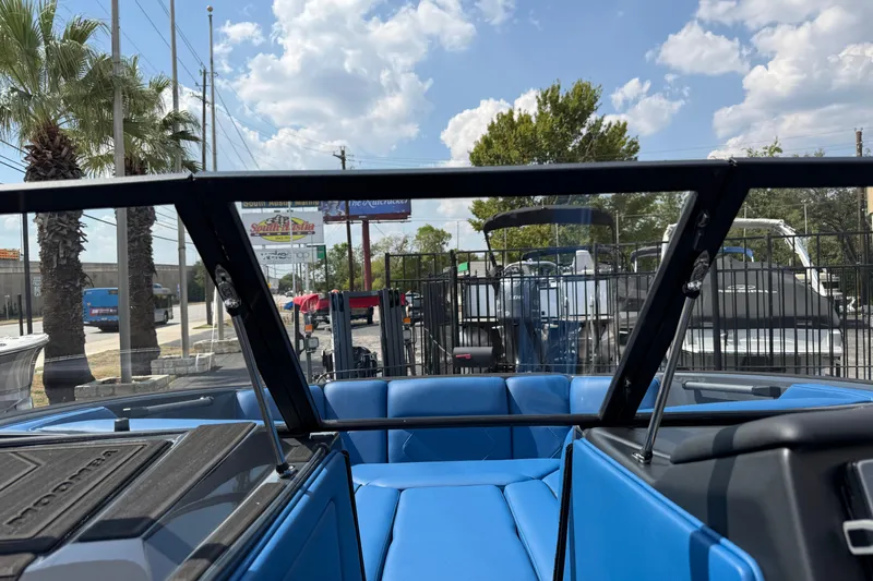 Slide: The Image of 2026 Moomba Tykon boat interior with blue seating, viewed through windshield under a sunny sky. - 39