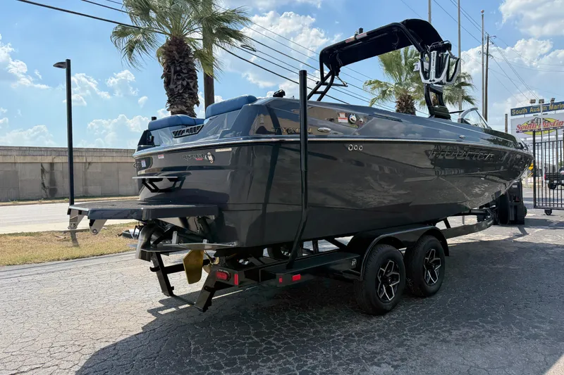 Slide: The Image of 2026 Moomba Tykon boat on trailer, parked outdoors under a sunny sky. - 5