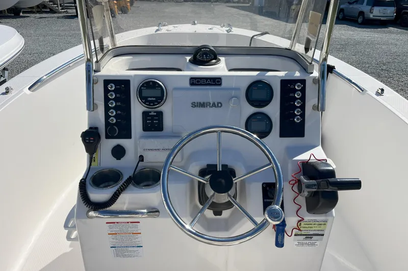 Slide: The Image of 2014 Robalo R180 Center Console boat dashboard with steering wheel and controls. - 2
