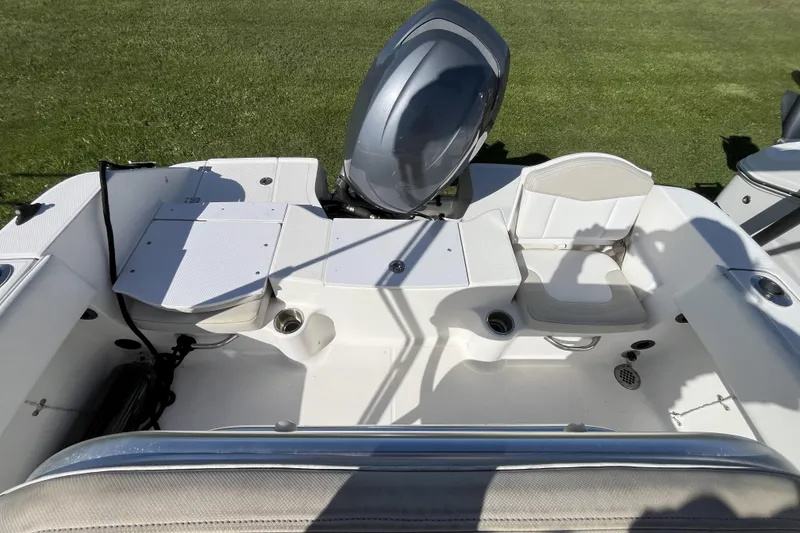 Slide: The Image of 2014 Robalo R180 Center Console boat interior with seating and engine, on grass background. - 8