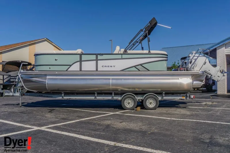 The Image of 2026 Crest Conquest 230 SLC pontoon boat on trailer in parking lot. - 1
