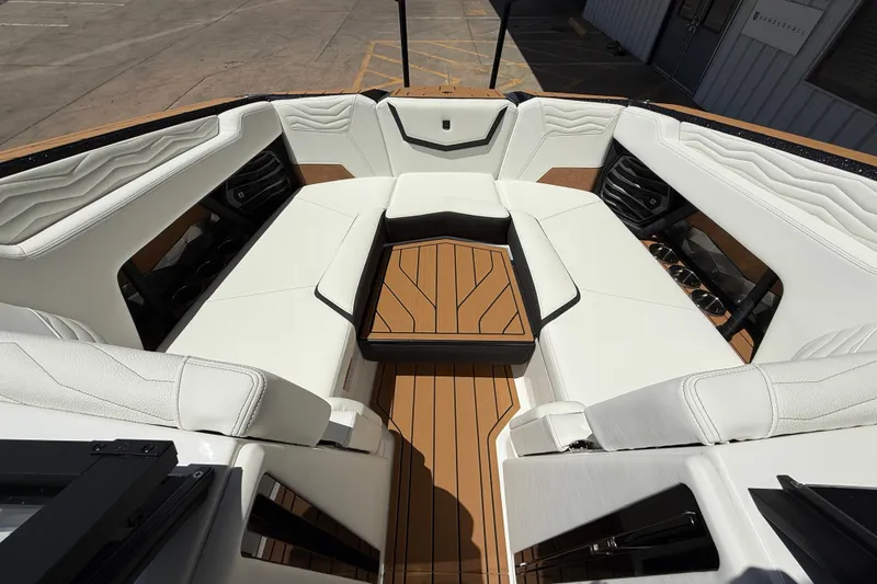 Slide: The Image of 2025 Nautique Super Air Nautique G23 boat interior with white seating and teak flooring. - 11