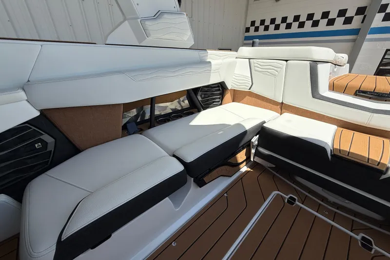 Slide: The Image of 2025 Nautique Super Air Nautique G23 interior with white and tan seating, modern design. - 13