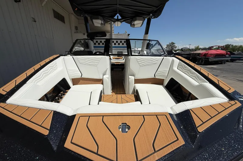 Slide: The Image of 2025 Nautique Super Air Nautique G23 boat interior with white seating and wood accents. - 14