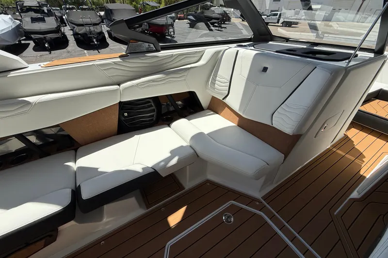Slide: The Image of 2025 Nautique Super Air Nautique G23 interior with white seating and teak flooring. - 16