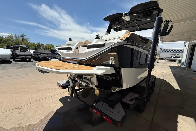 Slide: The Image of 2025 Nautique Super Air Nautique G23 boat on trailer, rear view, sunny day. - 4