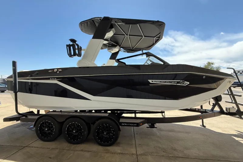 Slide: The Image of 2025 Nautique Super Air Nautique G23 boat on trailer, sleek black and white design. - 6