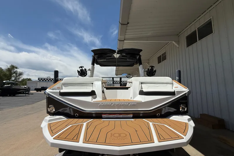 Slide: The Image of 2025 Nautique Super Air Nautique G23 boat, rear view under a clear sky. - 8