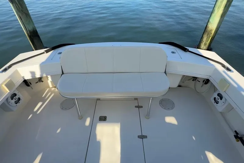 Slide: The Image of 2005 Albemarle 280 Express Fisherman boat deck with seating, docked by calm water. - 12