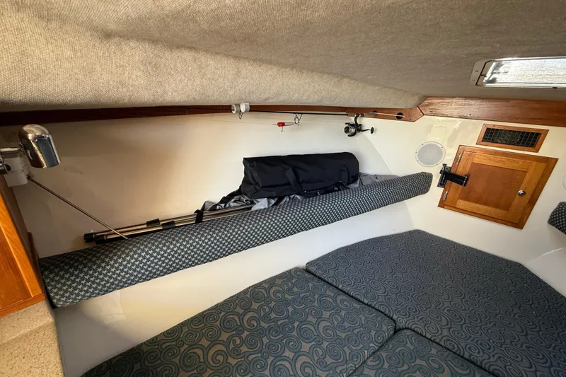 Slide: The Image of 2005 Albemarle 280 Express Fisherman cabin interior with cushioned seating and fishing gear storage. - 37