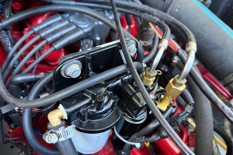 Slide: The Image of Engine components of a 2005 Albemarle 280 Express Fisherman boat, featuring hoses and connectors. - 55