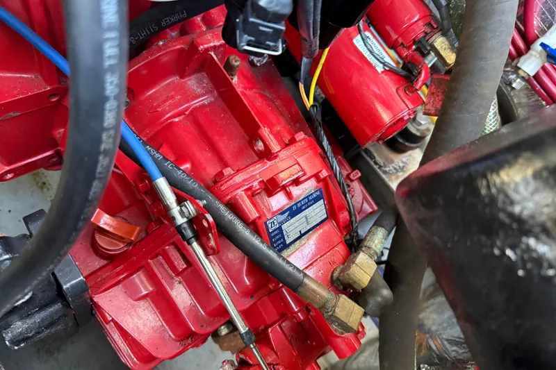 Slide: The Image of Engine components of a 2005 Albemarle 280 Express Fisherman boat, featuring red machinery and cables. - 56