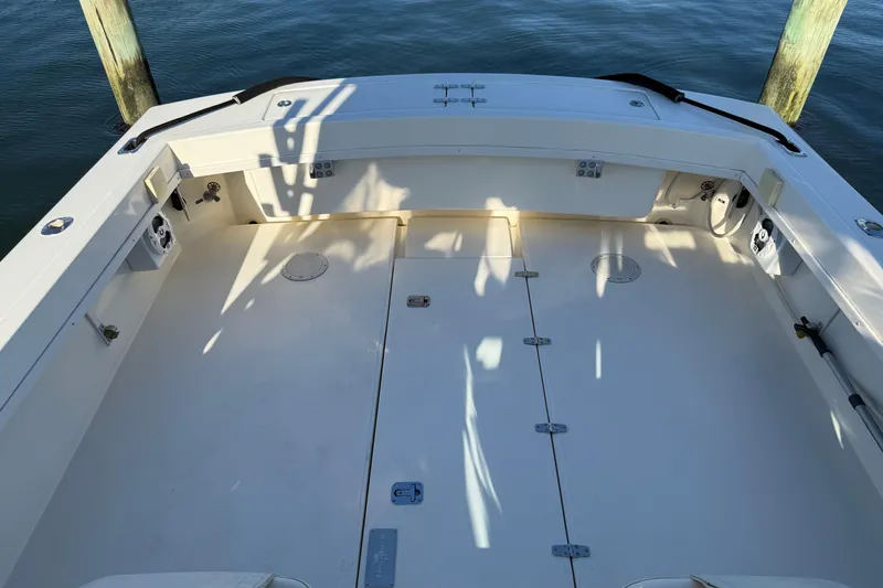Slide: The Image of 2005 Albemarle 280 Express Fisherman boat deck, spacious and well-maintained, docked by water. - 6