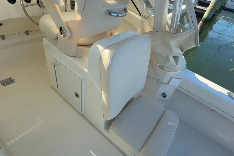 Slide: The Image of 2005 Albemarle 280 Express Fisherman boat interior with white seating and storage compartment. - 8