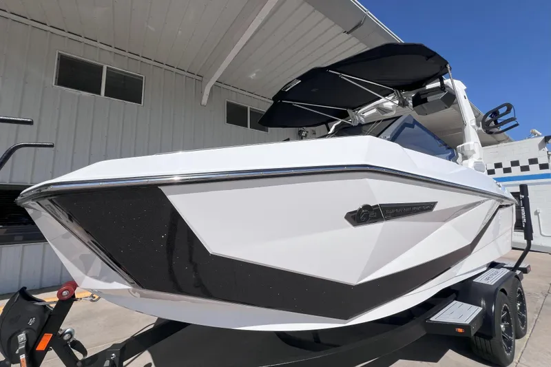 Slide: The Image of 2025 Nautique Super Air Nautique G21 boat with sleek design, parked outdoors. - 2