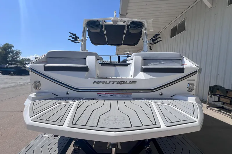 Slide: The Image of 2025 Nautique Super Air Nautique G21 boat, rear view, docked under a canopy. - 3