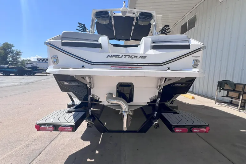 Slide: The Image of 2025 Nautique Super Air Nautique G21 boat rear view at a marina. - 4