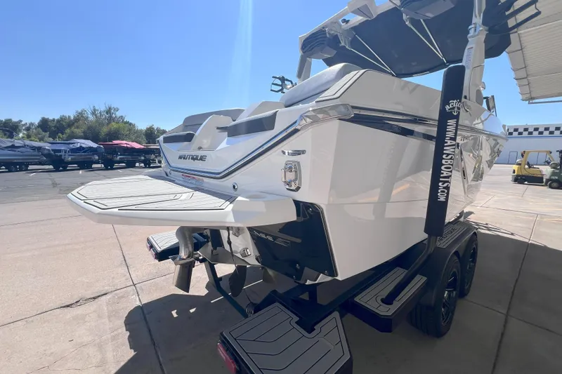 Slide: The Image of 2025 Nautique Super Air Nautique G21 boat on trailer, rear view in sunny outdoor setting. - 5