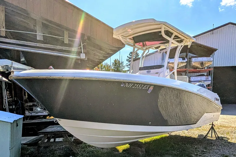 The Image of 2018 Wellcraft 242 Fisherman boat on display in a storage area, sunlight reflecting off hull. - 0
