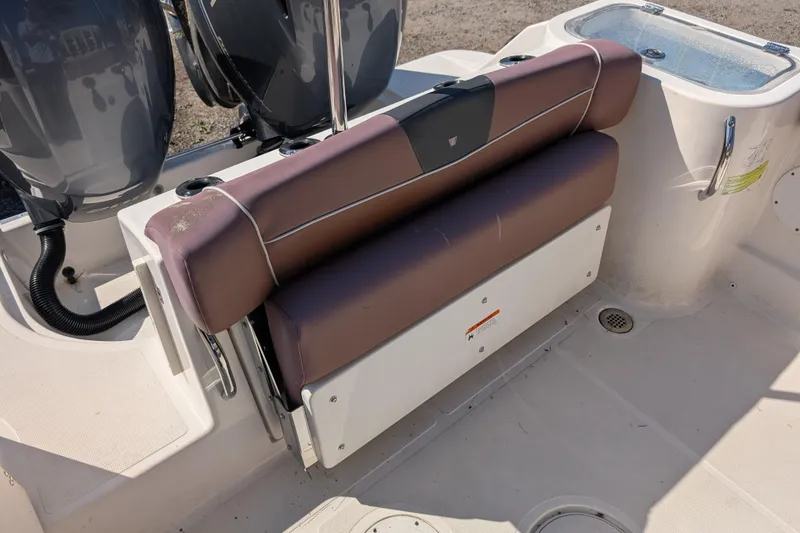 Slide: The Image of 2018 Wellcraft 242 Fisherman boat seat and engine area, featuring dual outboard motors. - 13