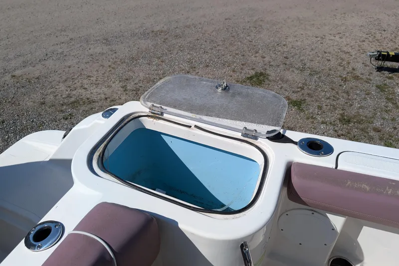 Slide: The Image of Open storage compartment on 2018 Wellcraft 242 Fisherman boat, featuring rod holders and seating. - 14