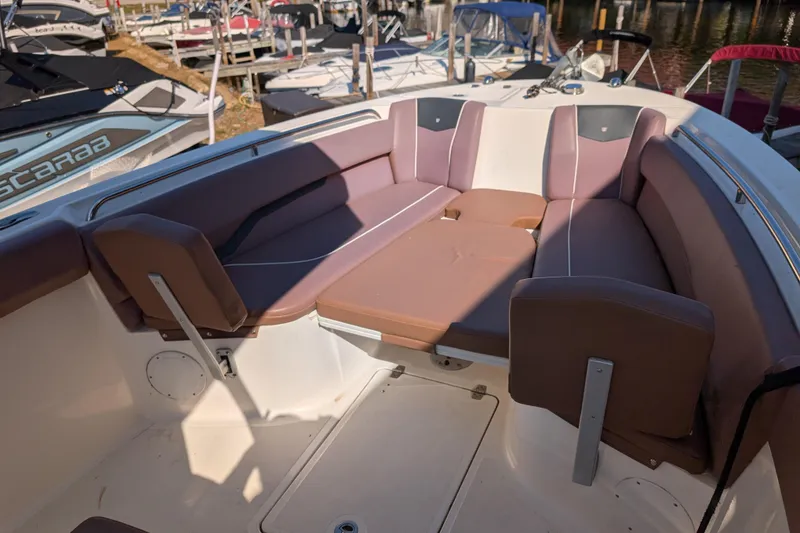 Slide: The Image of 2018 Wellcraft 242 Fisherman boat interior with cushioned seating in a marina setting. - 3
