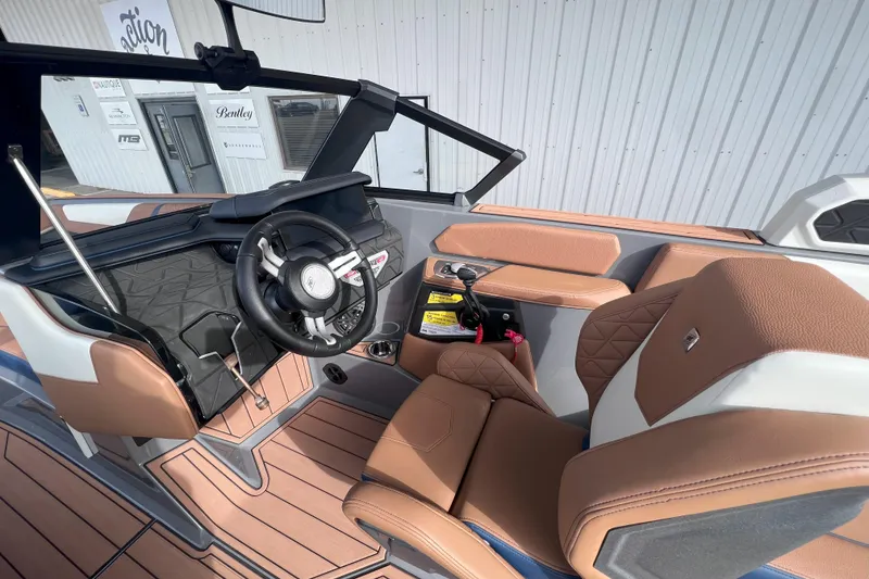 Slide: The Image of 2024 Nautique Super Air Nautique GS22 interior with tan leather seats and modern dashboard. - 11