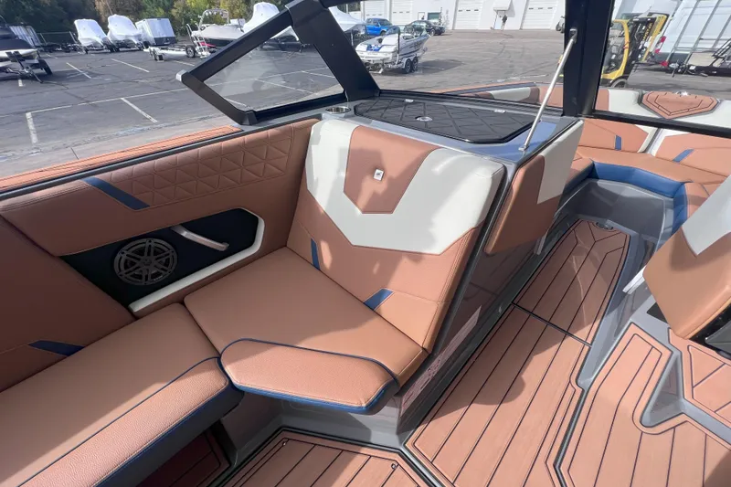 Slide: The Image of 2024 Nautique Super Air Nautique GS22 interior with tan and blue seating, modern design. - 12