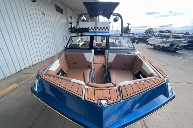 Slide: The Image of 2024 Nautique Super Air Nautique GS22 boat with sleek blue design and spacious seating. - 2