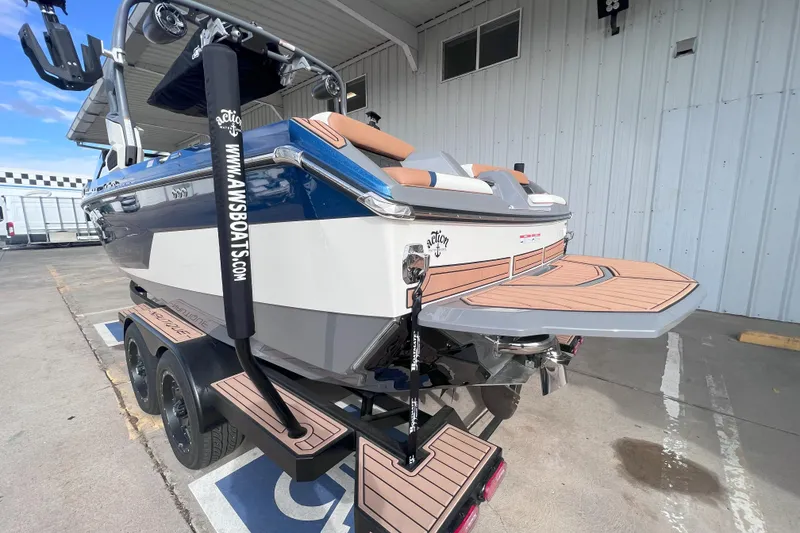 Slide: The Image of 2024 Nautique Super Air Nautique GS22 boat on trailer, rear view, in a marina setting. - 4