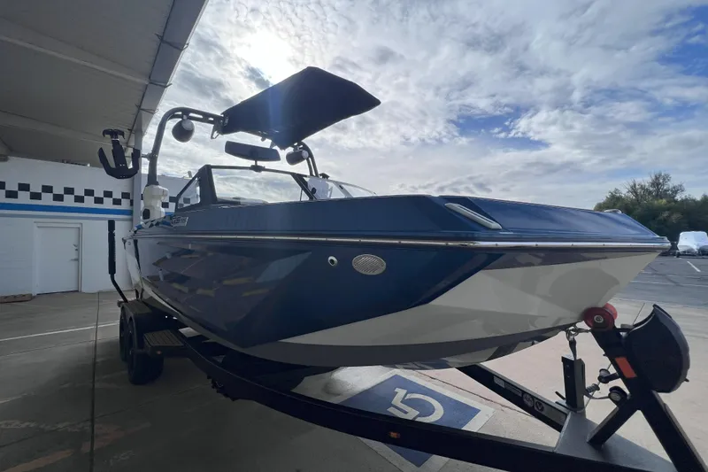 Slide: The Image of 2024 Nautique Super Air Nautique GS22 boat on trailer under cloudy sky. - 7