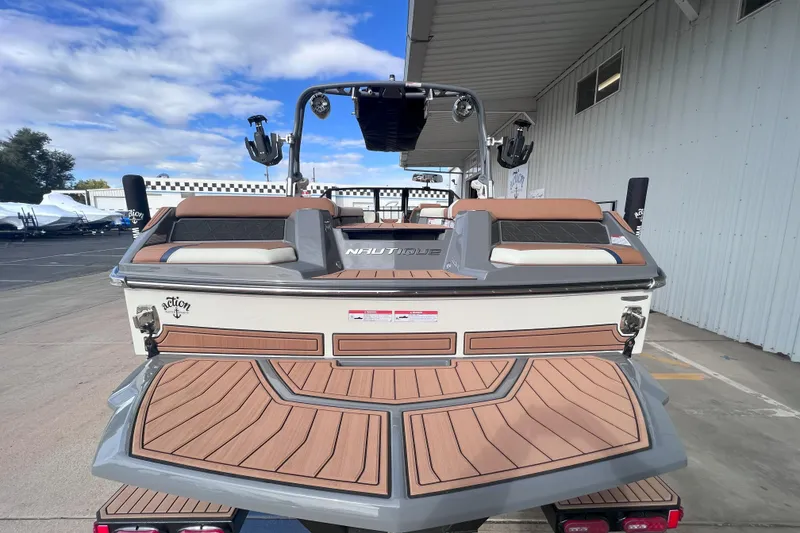 Slide: The Image of 2024 Nautique Super Air Nautique GS22 boat, rear view, docked under a canopy. - 9