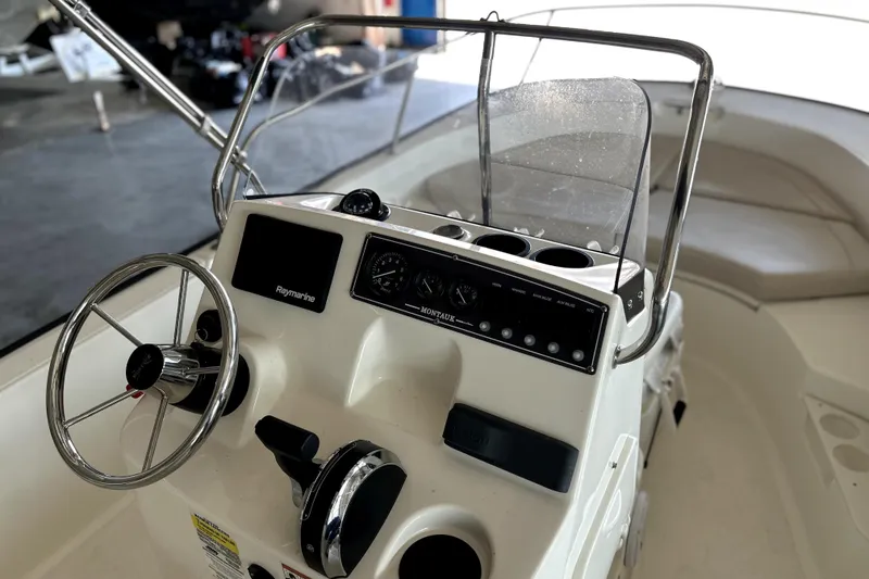 Slide: The Image of 2020 Boston Whaler 170 Montauk boat console with steering wheel and navigation controls. - 11