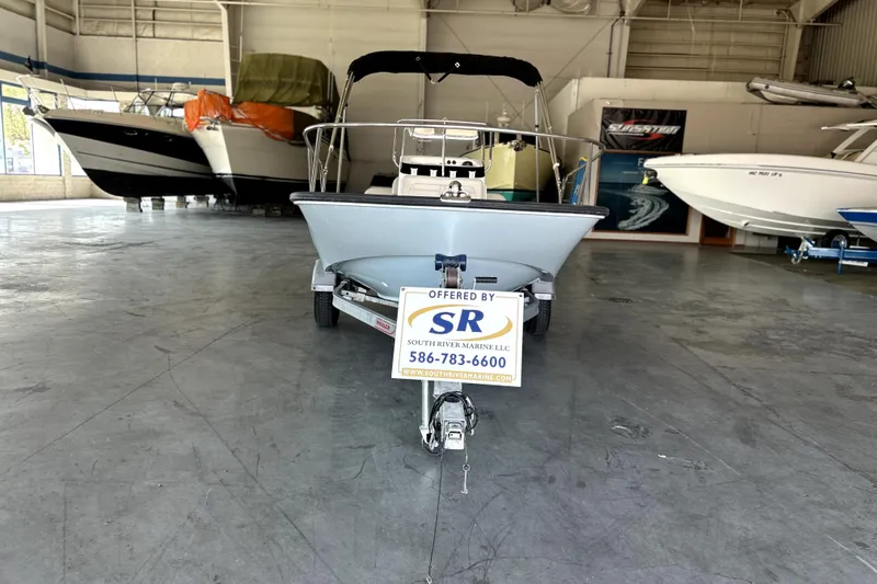 Slide: The Image of 2020 Boston Whaler 170 Montauk boat displayed in a showroom with other boats. - 2