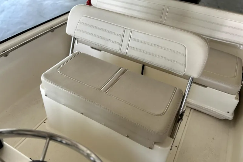 Slide: The Image of 2020 Boston Whaler 170 Montauk boat interior with beige seating and steering wheel. - 9