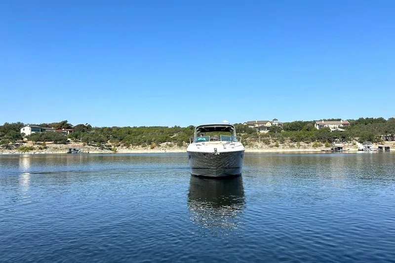Slide: The Image of 2014 Sea Ray 350 Sundancer on calm lake with scenic shoreline background. - 13