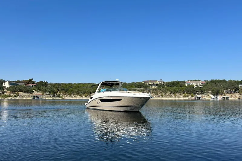 Slide: The Image of 2014 Sea Ray 350 Sundancer cruising on a calm lake under a clear blue sky. - 15