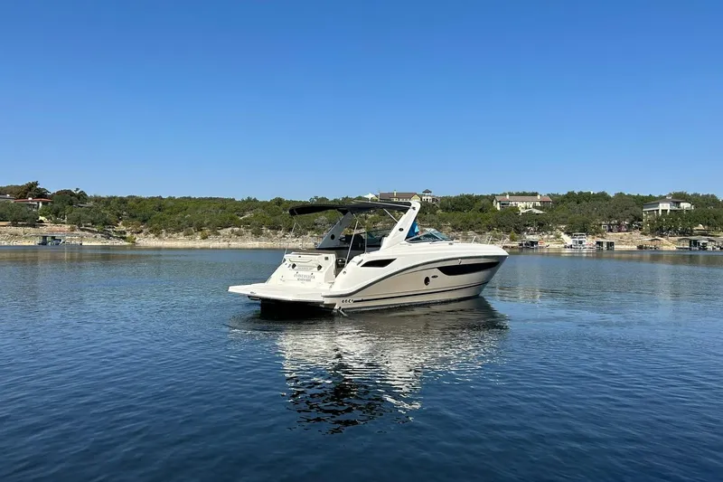 Slide: The Image of 2014 Sea Ray 350 Sundancer yacht on calm lake with clear blue sky. - 20