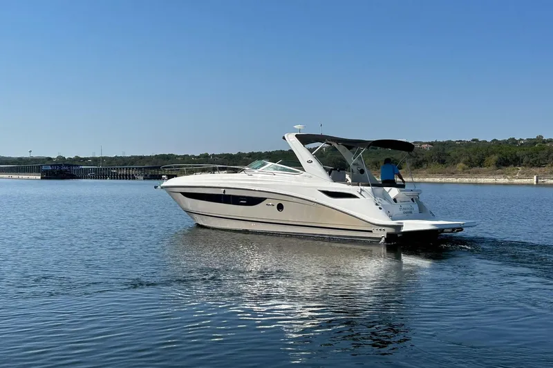 Slide: The Image of 2014 Sea Ray 350 Sundancer cruising on a calm lake under a clear blue sky. - 26