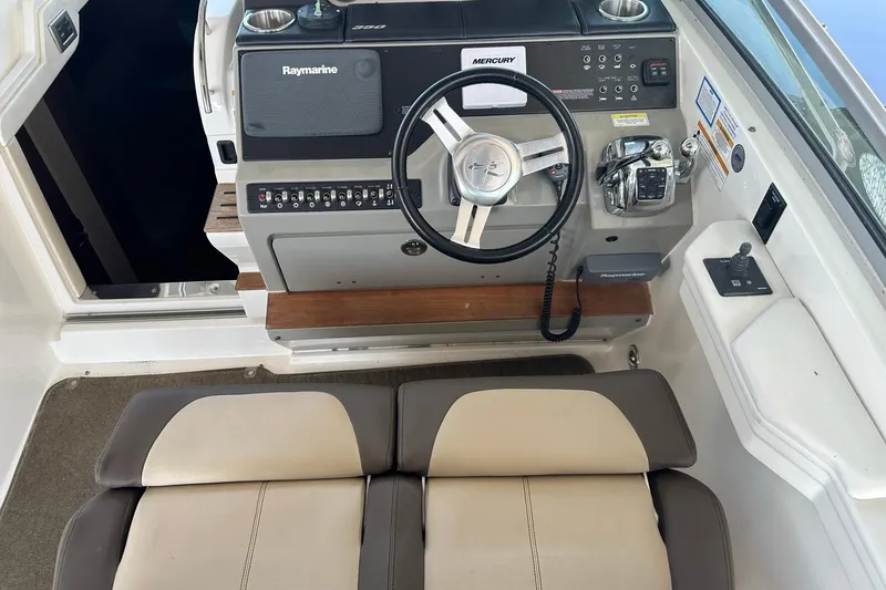 Slide: The Image of 2014 Sea Ray 350 Sundancer helm with steering wheel, controls, and Raymarine electronics. - 47