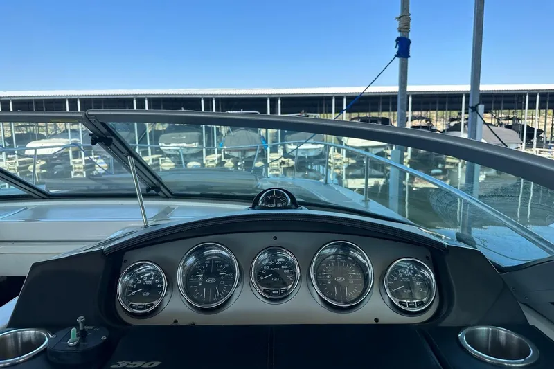 Slide: The Image of 2014 Sea Ray 350 Sundancer dashboard with gauges, marina view in background. - 49