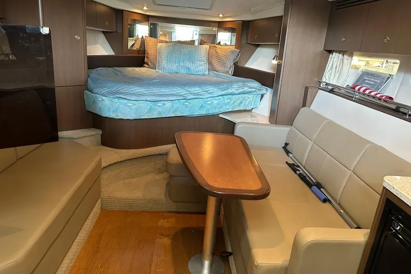 Slide: The Image of Interior of 2014 Sea Ray 350 Sundancer with cozy bed and seating area. - 58