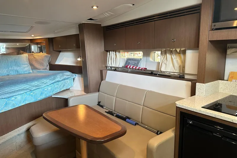 Slide: The Image of Interior of 2014 Sea Ray 350 Sundancer yacht with bed, seating, and kitchenette. - 61