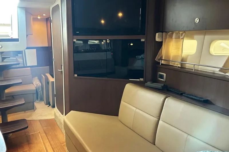 Slide: The Image of 2014 Sea Ray 350 Sundancer interior with modern seating and entertainment area. - 63