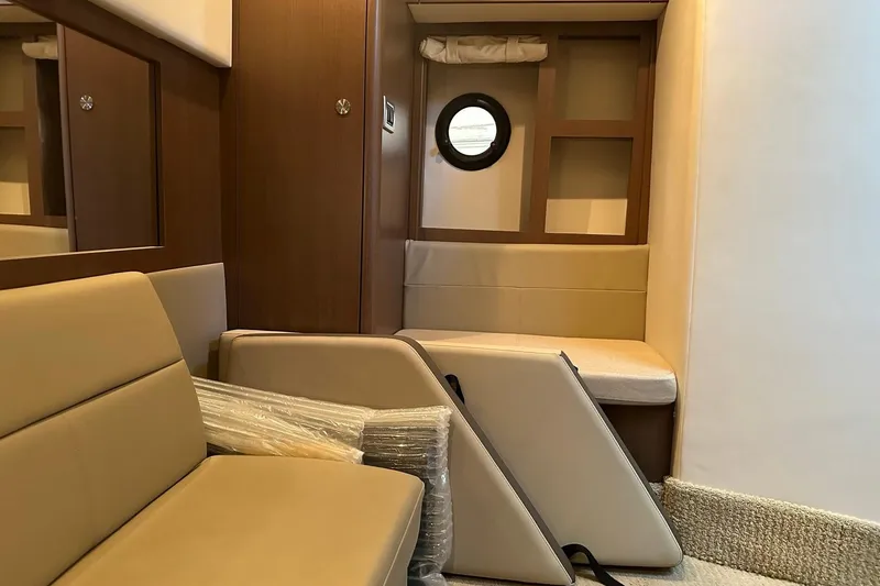 Slide: The Image of Interior of 2014 Sea Ray 350 Sundancer yacht with beige seating and wooden accents. - 69