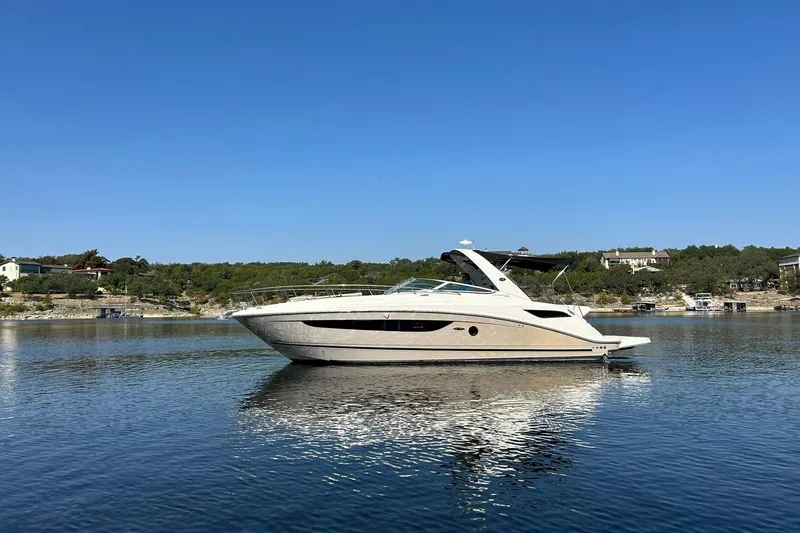 Slide: The Image of 2014 Sea Ray 350 Sundancer yacht on calm water under clear blue sky. - 8