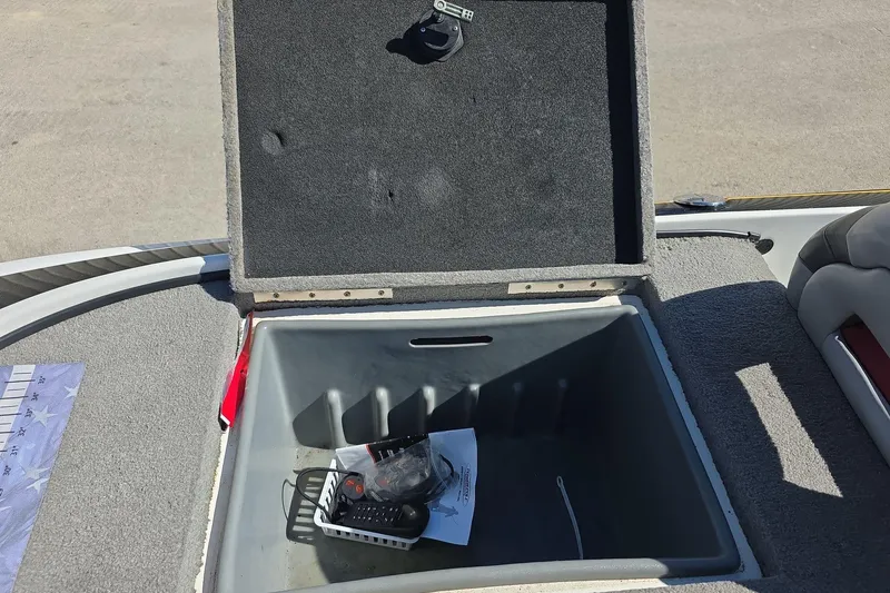 Slide: The Image of Open storage compartment in a 2011 Nitro Z-8 boat, containing miscellaneous items. - 17