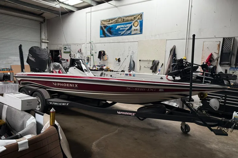 Slide: The Image of 2017 Phoenix 920 ProXP boat in a garage, red and white design, on a trailer. - 1