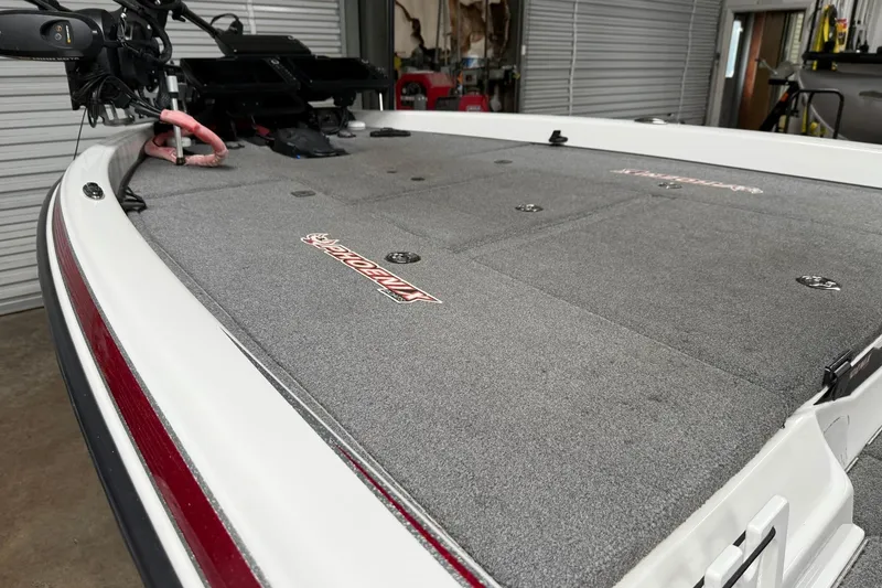 Slide: The Image of 2017 Phoenix 920 ProXP boat deck with gray carpet and equipment in a garage setting. - 8